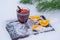 Glass with mulled red wine on a bed of snow and white background, close up. Christmas beverage