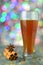Glass of mulled spiced beer on bokeh background