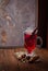 Glass of mulled wine on old wooden table in winter frosty day