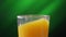 Glass with orange juice. Ice cube fall, creating a lot of splashing. Slow motion