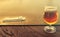 Glass of original Dutch beer on bar desk against Amsterdam waterway at sunset light