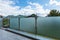 A glass parapet of a modern building balcony overlooking hills