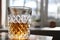 A glass patterned glass with whiskey or cognac stands on the table on a white background the glass is illuminated side
