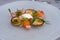 A glass plate filled with caviar, small toasts and vegetables as an apetizer at a luxury restaurant