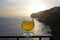 A glass of poncha at sunset on Madeira with stunning views of the rocky coastline.