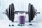 Glass of Protein Shake with milk and blueberries, L-Carnitine capsules and a dumbbell in background. Sports bodybuilding nutrition