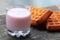 Glass of raspberry yogurt and two freshly baked waffles against blurred blue background