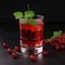 Glass of red currant syrup drink with fresh red currants and mint