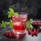 Glass of red currant syrup drink with fresh red currants and mint