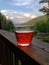 Glass of Red Liquor Sitting on the Front Deck Railing of a Mountain Cabin