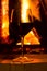 Glass of red vine near fireplace close up