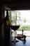 Glass of red wine and bottle on a bar counter on blurred door background