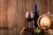 Glass of red wine with bottle barrel grapes and wooden background