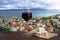 Glass of red wine with brie cheese against view of the small town Omis surrounded with mountains, Cetina river and sea, Makarska