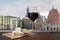 Glass of red wine with brie cheese against view of Town Hall square in old town Riga, Latvia