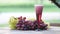 Glass of red wine with bunches of fresh grapes as a background