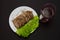 Glass of red wine and fork sliced pork meat with lettuce leaves on a plate