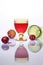 A glass of red wine and fruit on a light background