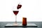 Glass of red wine garnished with grape and piece of hard cheese