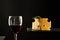 Glass of red wine beside pieces of aromatic cheese and branch of rosemary