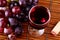 Glass of red wine with red grapes