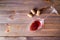 Glass with red wine remains with corks on a wooden table. Top view