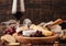 Glass of red wine with selection of various cheese on the board and grapes on wooden background. Blue Stilton, Red Leicester and