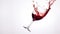 Glass of red wine spilling on white background