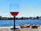 Glass of red wine on table in beach yachting club restaurant on horizon boat  in harbor seascape blue sky and seashell lifestyle