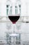 Glass of red wine on a watery surface