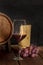 A glass of red wine with a wine barrel, a large piece of swiss cheese