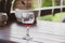 Glass of red wine in wooden table. Wineglass in patio. Alcoholic drinks. Summer relax. Vineyard in provence. Red wine concept.