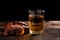 Glass of reishi tea and dried Lingzhi mushroom on dark wooden floor.