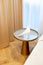 Glass round bedside table with gold in a modern beige interior. Interior Design. Soft selective focus, artistic noise