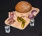 Glass of russian vodka and snack lard bream pickled cucumbers onion garlic bread on a wooden board on a black background