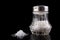 Glass salt shaker with metal cap on the kitchen table. Kitchen accessories for seasoning dishes