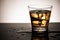 Glass of scotch whiskey with ice cube,Cold beverage of alcohol and reflection on glass