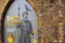 The glass showcase of the Tower of London. Golden letters and signs with guard with raven sitting on his hat. Brick arc framing