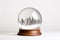 Glass snow globe with frozen snowy fir trees inside. Magical Christmas crystal ball, minimalist crystal magic ball with pine trees