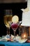 A glass with sorbet and a cookie with champagne glasses and a wedding cake in the background served during a fancy wedding