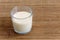 Glass of soya milk with froth on bamboo mat.