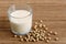 Glass of soya milk with froth on bamboo mat with spilled soya be