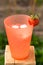 Glass with sparkling water and frash bright strawberries in a summer garden. Shallow depth of field. Selective focus