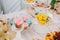 Glass stand with lid with pink cupcake next to flowers and other sweets on candy bar