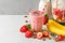 Glass of strawberry and banana vegan smoothie or milkshake made of almond milk with fresh juicy ingredients in blender