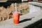 Glass of strawberry and mango bubble tea closeup on city background