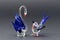 A glass swan and small bird ornaments, made with clear, blue and red glass