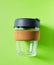 Glass takeaway coffee cup on green background