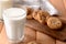 Glass of tasty milk and cookies on wooden table