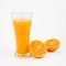 The glass of tasty pure orange juice and fresh orange half